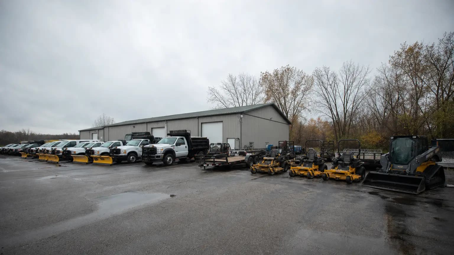 Landscaping and snow-removal fleet staged at a maintenance yard.